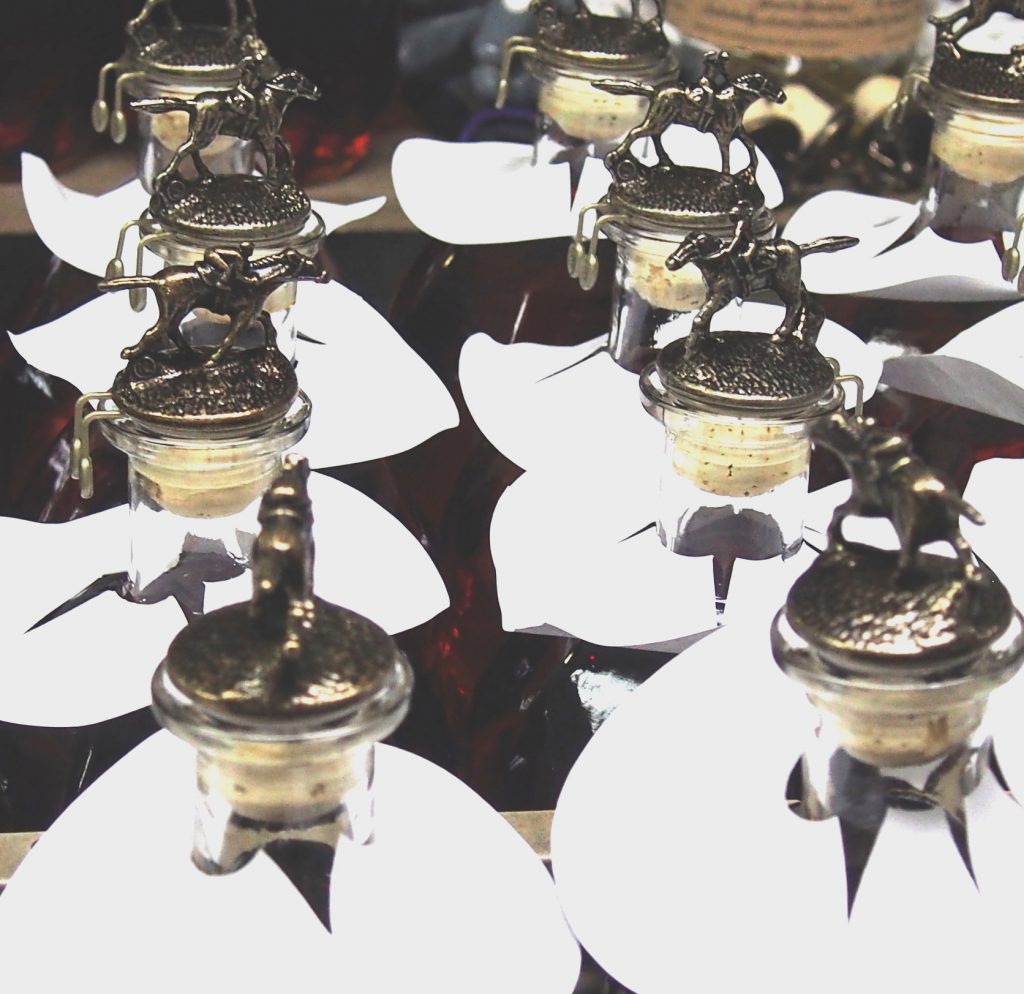 Jockey bottle stoppers being applied to Blanton's bottles.