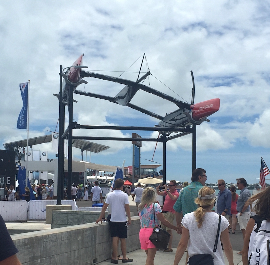Guests entering the America's Cup Village, Bermuda, walk beneath the hull of an Oracle Team USA catamaran