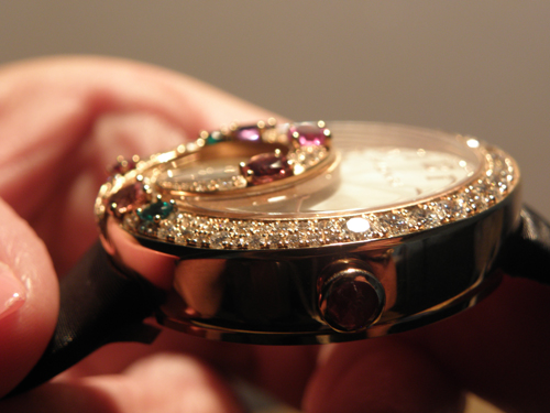 The tourbillon cage is outlined in a 3D swirl of gold and gemstones